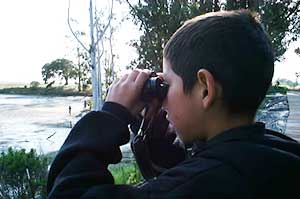kid looking thru binoculars on field trip
